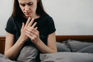 Young woman massaging her painful hand